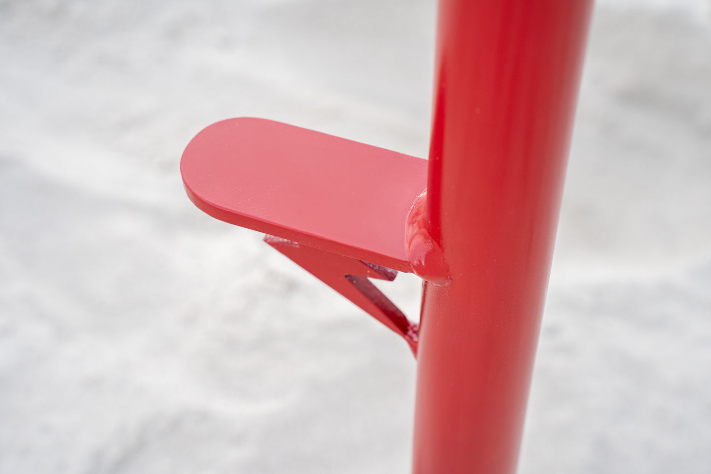 Custom red aluminum surf fishing rod holder beach spike foot close up