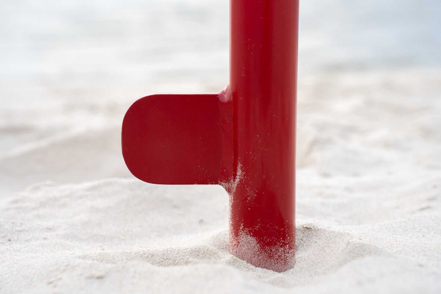 Custom red aluminum surf fishing rod holder beach spike stabilizer close up