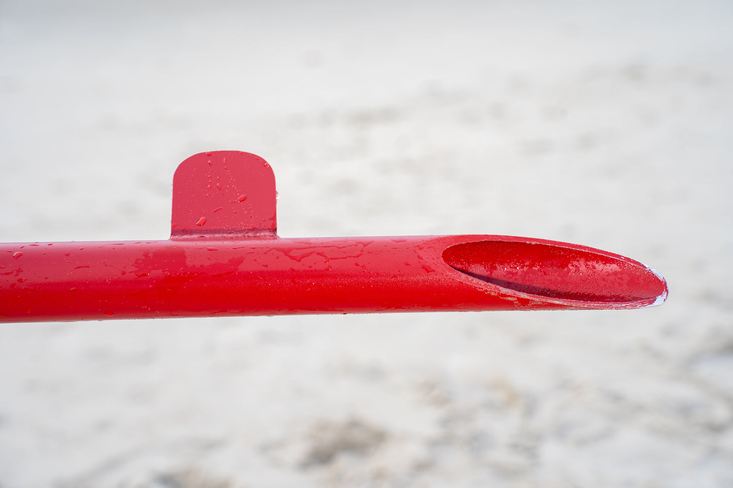 Custom red aluminum surf fishing rod holder beach spike end part close up