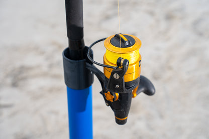 Custom blue aluminum surf fishing rod holder beach spike cap close up holding fishing rod